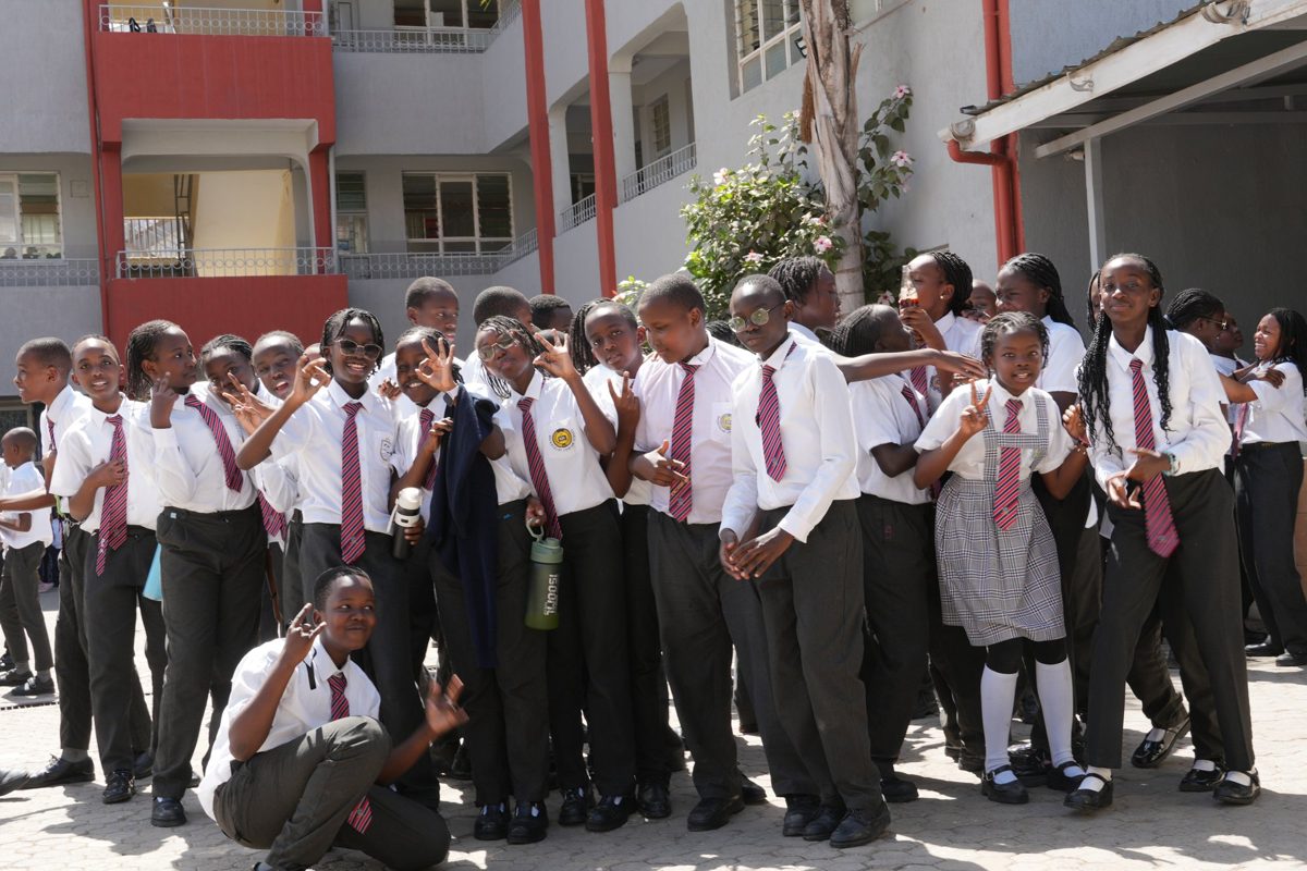 A large group of Junior Secondary pupils in uniform in the courtyard