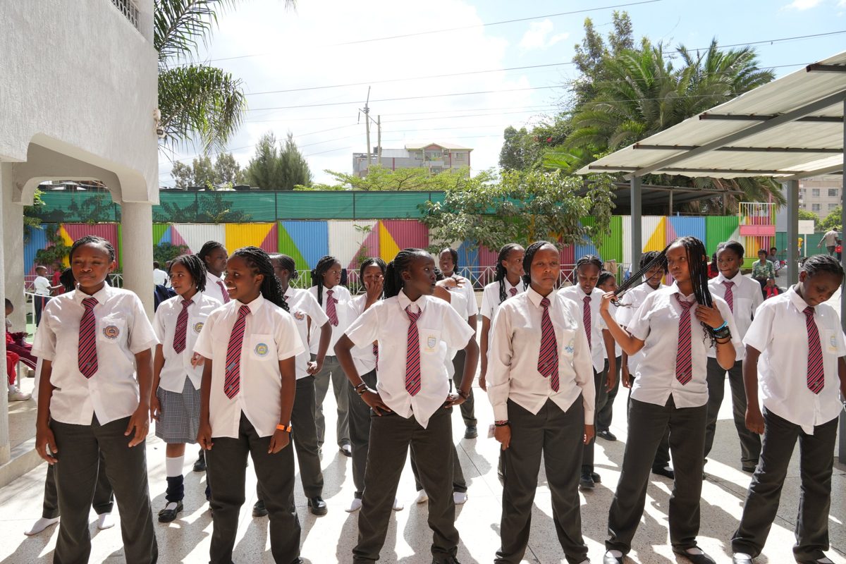 Junior Secondary pupils in a line under the playground shade