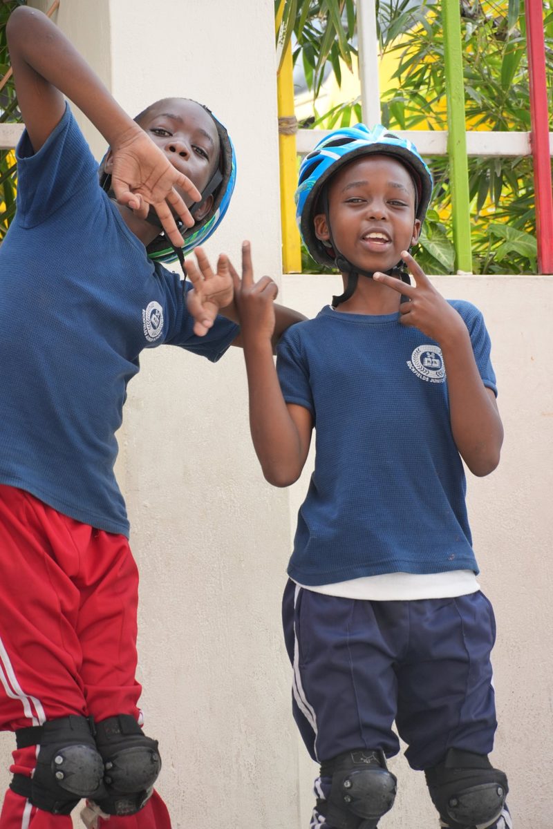 Two Kindergarten children in helmets and pads on the yard